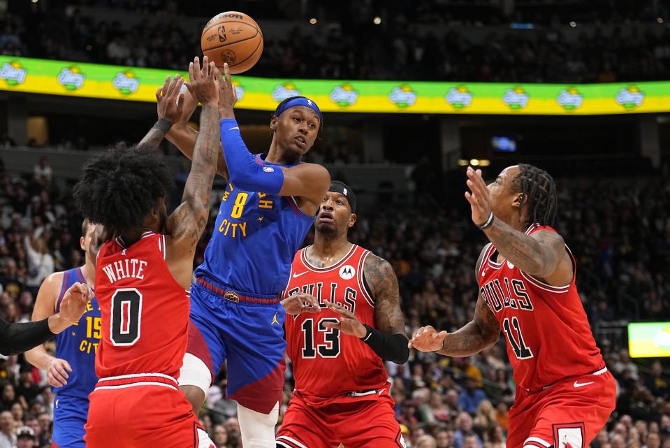 Denver Nuggets forward Peyton Watson (8) passes under pressure from Chicago Bulls guard Coby White (0), Torrey Craig (13), and DeMar DeRozan (11) during the second quarter of an NBA basketball game Saturday, Nov. 4, 2023, in Denver. (AP Photo/Jack Dempsey)