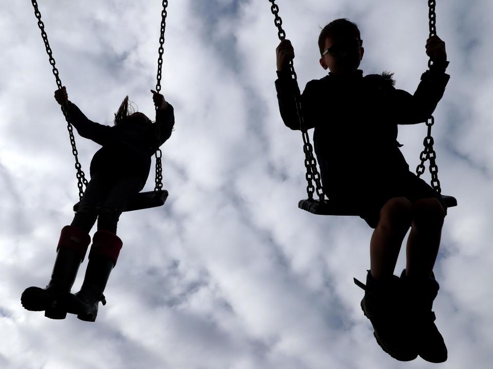 Stock image of children playing on the swings: PA Images