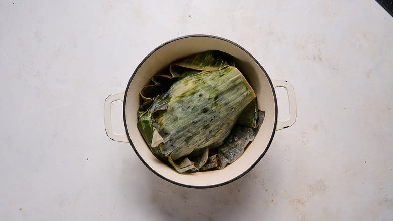 preparing kalua pork with banana leaves