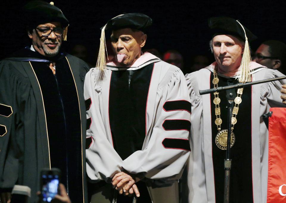 Harry Belafonte, second from left, playfully sticks out his tongue after receiving an honorary doctor of music degree from Berklee College of Music President Roger H. Brown, right, at the Berklee Performance Center in Boston, Thursday, March 6, 2014. (AP Photo/Michael Dwyer)