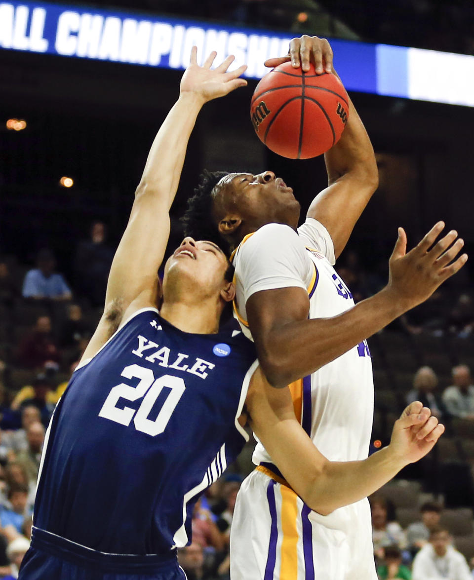 Yale 's Paul Atkinson (20) and LSU's Kavell Bigby-Williams battle for a rebound during the first half of a first round men's college basketball game in the NCAA Tournament in Jacksonville, Fla. Thursday, March 21, 2019. (AP Photo/Stephen B. Morton)
