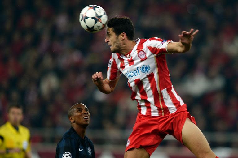 Manchester United's Ashley Young (L) looks on as Olympiakos' Ivan Marcano heads the ball during their UEFA Champions League round of 16 first leg match, at the Karaiskaki stadium in Athens, on February 25, 2014