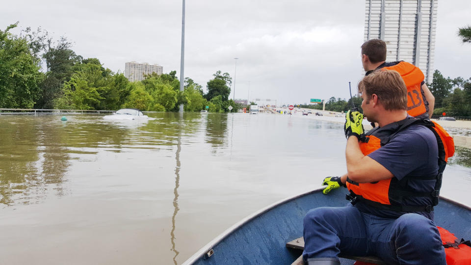 Firefighters with the Houston Fire Department check on a submerged vehicle off Interstate 10 in Houston&nbsp;on Sunday. (Photo: David Lohr/HuffPost)