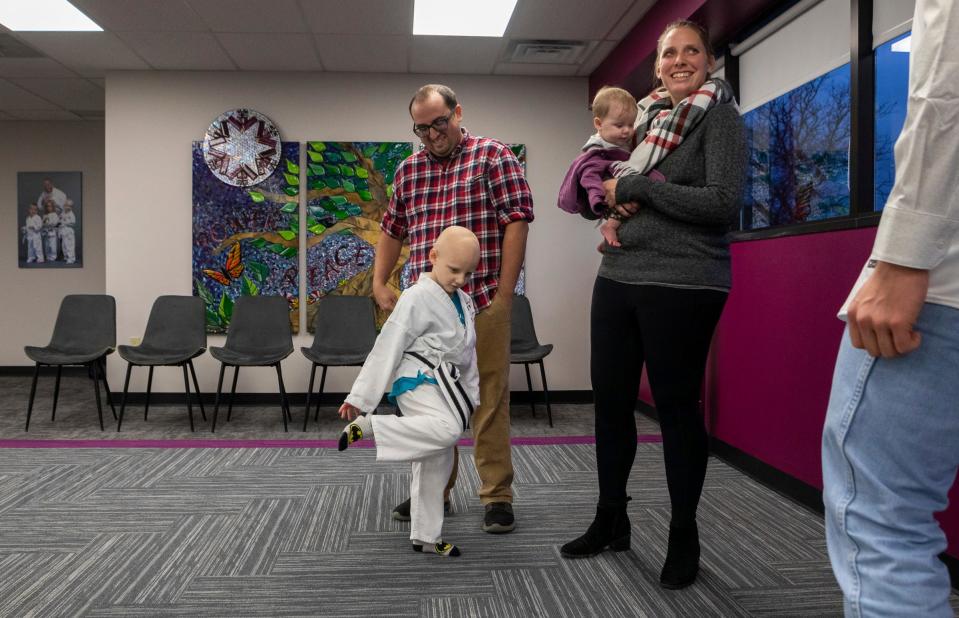 Cody Vela, left, watches his 5-year-old son, Cailen Vela, middle, as he stands next to his mom, Aly Vela, during a conversation with Tigers pitcher Sawyer Gipson-Long before the start of a Kids Kicking Cancer class inside The Charach Global Kids Kicking Cancer Center in Southfield on Wednesday, Dec. 6, 2023.