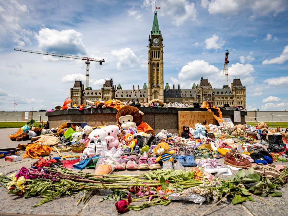 Shoes, stuffed toys and other items were placed around the Centennial Flame in June following the apparent discovery of children's remains at a former B.C. residential school. The memorial grew even larger before being removed Friday. (Brian Morris/CBC - image credit)