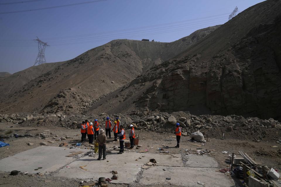 Trabajadores forenses trabajan en el sitio donde se encontraron las víctimas de una masacre de un escuadrón militar de la muerte en 1992 en Cineguilla, Perú, el lunes 30 de mayo de 2022.. (AP Foto/Martin Mejia)