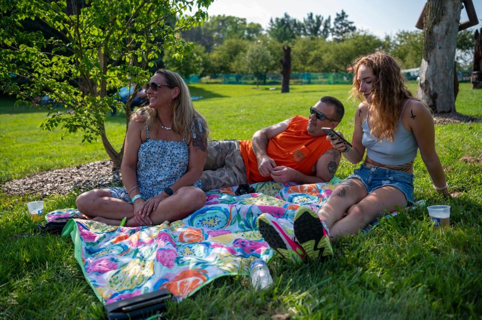 Amy Hind, Jimmy Brummels and Bethany Hind watch the first set of Leilapalooza on Thursday, July 29, 2021 at Leila Arboretum in Battle Creek.
