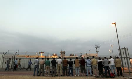 Palestinian labourers pray after crossing through Israel's Eyal checkpoint near the West Bank town of Qalqilya, in this June 13, 2010 file photo. REUTERS/Baz Ratner/Files