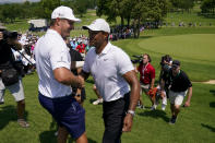 Bryson Dechambeau greets Tiger Woods after a practice round for the PGA Championship golf tournament, Wednesday, May 18, 2022, in Tulsa, Okla. (AP Photo/Matt York)
