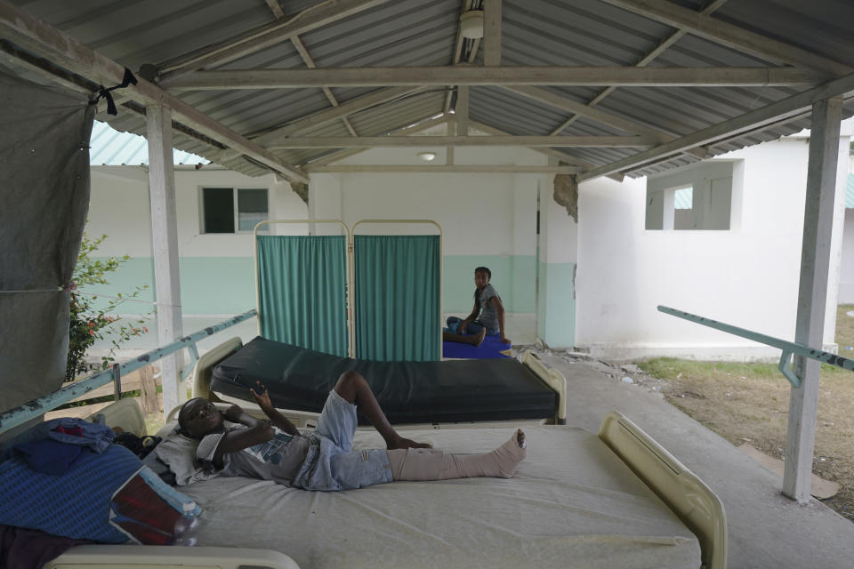 People injured in the earthquake rest on beds outside the Ofatma Hospital because some interior walls were cracked by the earthquake in Les Cayes, Haiti, Wednesday, Aug. 18, 2021. (AP Photo/Fernando Llano)