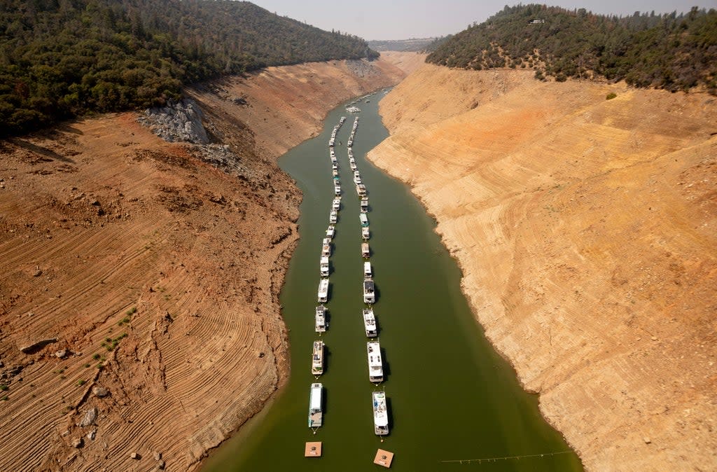 Houseboats sit in a narrow section of water in a depleted Lake Oroville in California, which is currently at 23% of its capacity, suffering from extreme levels of drought (AFP via Getty Images)