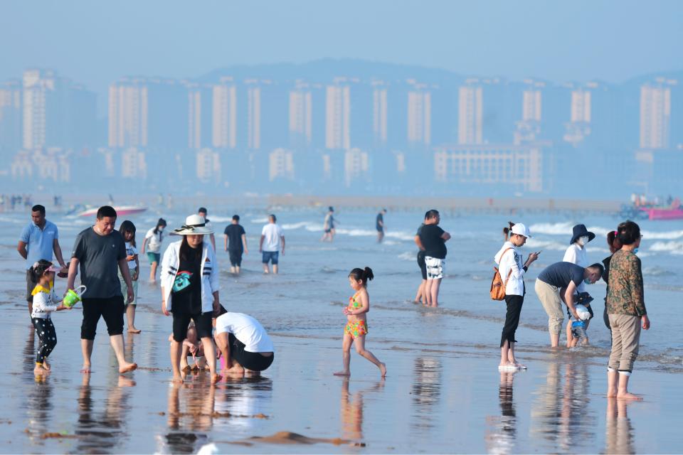 QINGDAO, CHINA - JUNE 3, 2020 - Tourists play between the sea and the beach. Qingdao, Shandong Province, China, June 3, 2020.- PHOTOGRAPH BY Costfoto / Barcroft Studios / Future Publishing (Photo credit should read Costfoto/Barcroft Media via Getty Images)