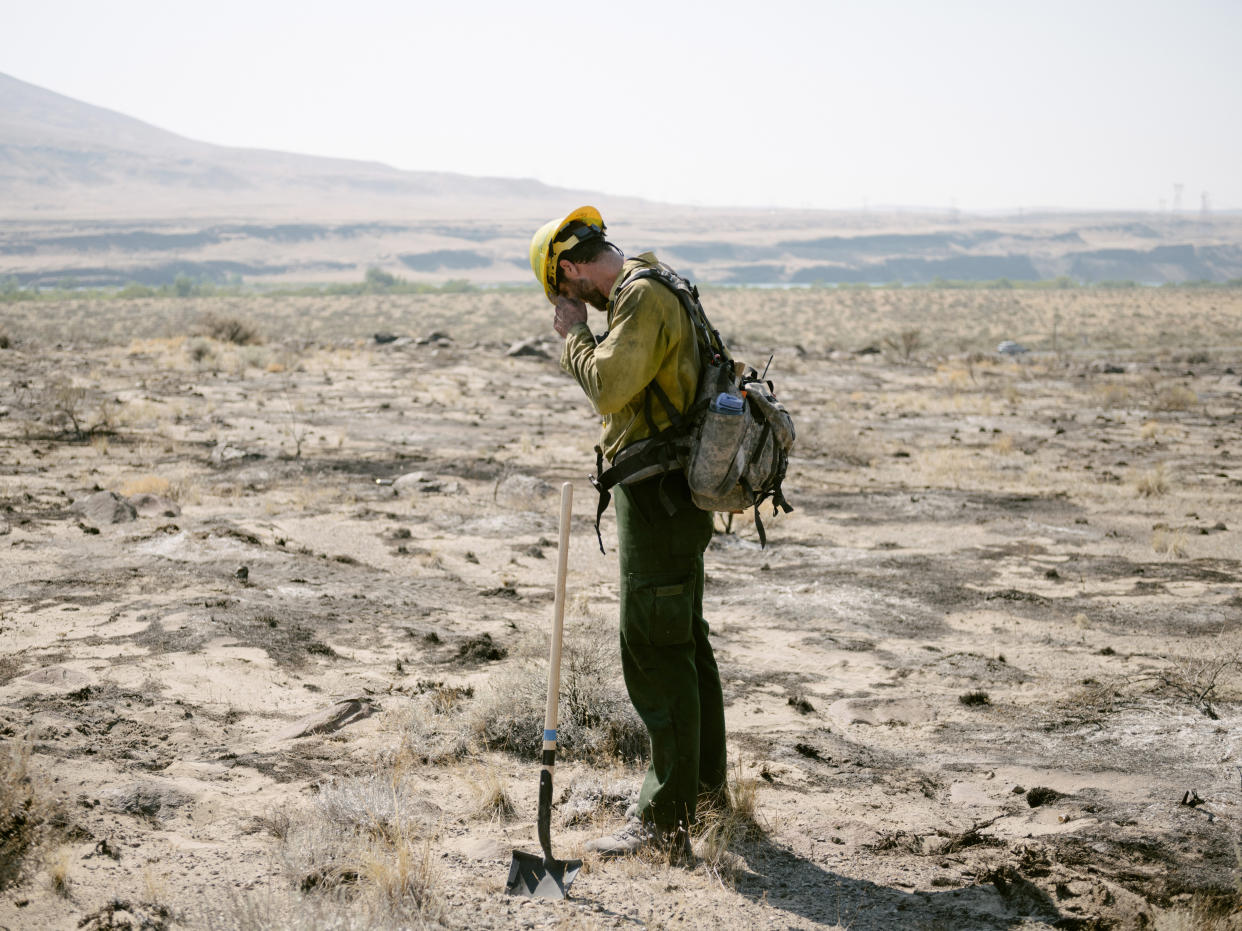 Miembro del Servicio de Pesca y Vida Silvestre de Estados Unidos hace una pausa en medio del calor de más de 43,3 grados Celsius tras apagar un pequeño incendio forestal justo al norte de Mattawa, Washington, el 30 de junio de 2021. (Grant Hindsley/The New York Times).