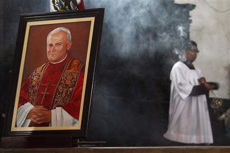 A picture of the late Pope John Paul II is seen during a mass at the cathedral in Xochimilco, Mexico City April 10, 2014. REUTERS/Edgard Garrido