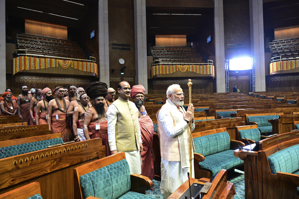 Indian prime minister Narendra Modi carries a royal golden sceptre to be installed it near the chair of the speaker during the start of the inaugural ceremony of the new parliament building, in New Delhi, India, Sunday, May 28, 2023. The new triangular parliament building, built at an estimated cost of $120 million, is part of a $2.8 billion revamp of British-era offices and residences in central New Delhi called "Central Vista". (AP Photo)