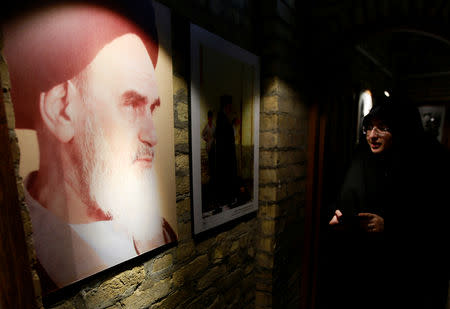 A female Iranian pilgrim looks at the picture of the late Iranian revolutionary leader Ayatollah Ruhollah Khomeini, at the former home of the late Ayatollah Ruhollah Khomeini, in Najaf, Iraq February 9, 2019. Picture taken February 9, 2019. REUTERS/Alaa al-Marjani