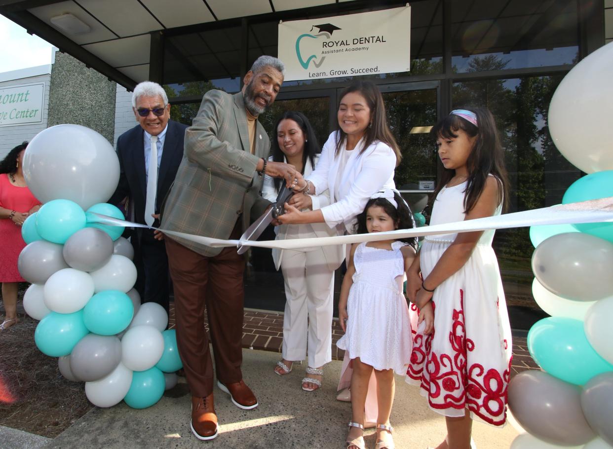 Gastonia Mayor Walker Reid helps owners Lupe Torres and Modesta Vera cut the ribbon during the Grand Opening of Royal Dental Assistant Academy Saturday morning, May 13, 2023, at their location on Remount Road.