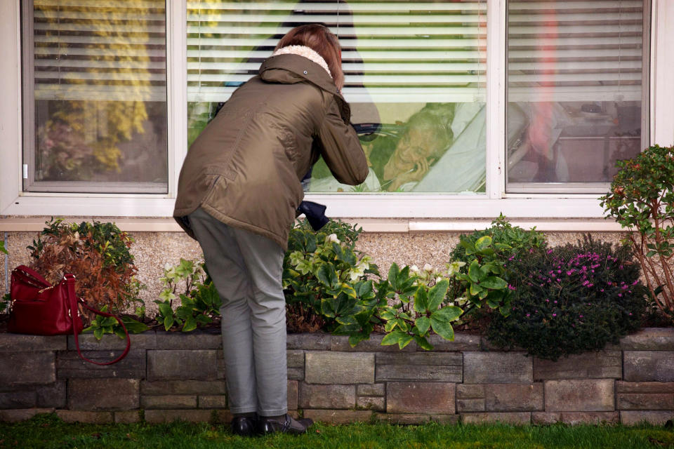 Image: Lori Spencer speaks to her mother, Judie Shape, through a window at the Life Care Center of Kirkland in Washington on March 8, 2020. The assisted living facility is linked to several confirmed coronavirus cases in the state. (David Ryder / Reuters file)