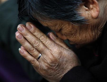 A believer prays during a weekend mass at an underground Catholic church in Tianjin in this November 10, 2013. REUTERS/Kim Kyung-Hoon