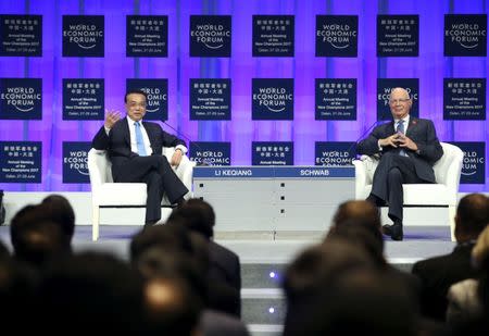 Chinese Premier Li Keqiang (L) and World Economic Forum Founder and Executive Chairman Klaus Schwab attend the World Economic Forum in Dalian, Liaoning province, China June 27, 2017. CNS/Liu Zhen via REUTERS