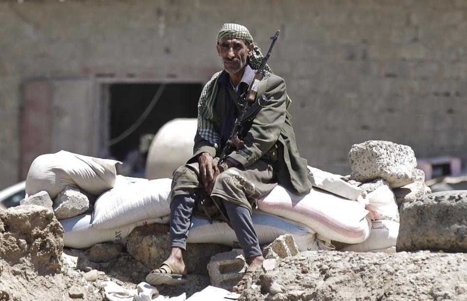 A Shi'ite Houthi rebel sits at a checkpoint in Sanaa September 21, 2014. Shi'ite Houthi rebels and government forces fought for a fourth straight day in the Yemeni capital, residents said, despite the announcement of a U.N.-brokered agreement due to be signed later on Sunday. (REUTERS/Khaled Abdullah)