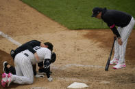 New York Yankees manager Aaron Boone, right, looks on as staff attend to Aaron Hicks, left, after he slipped during the eighth inning of a baseball game against the Washington Nationals at Yankee Stadium, Sunday, May 9, 2021, in New York. Hicks recovered and was able to complete his at-bat. (AP Photo/Seth Wenig)