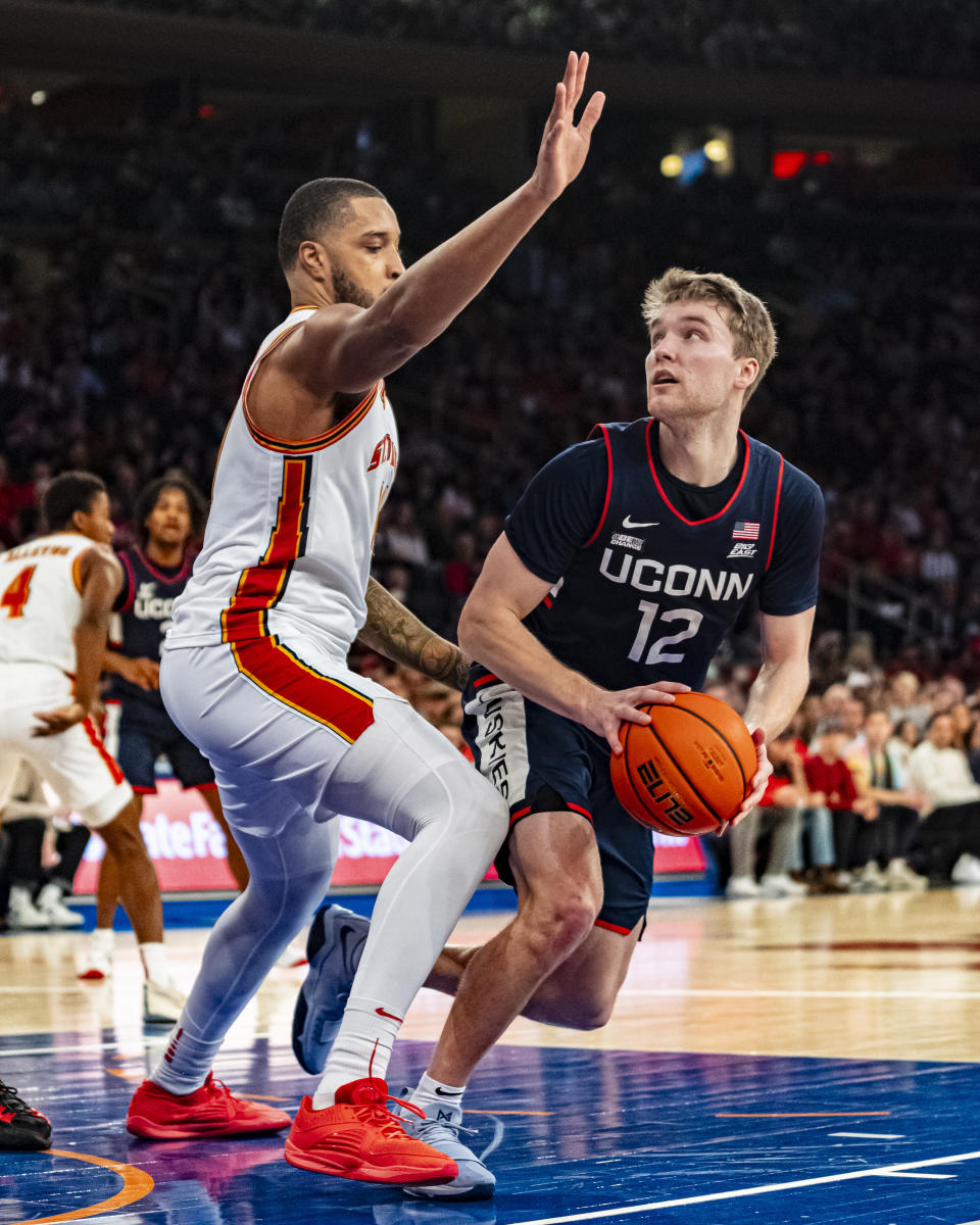 UConn guard Cam Spencer (12) looks to shoot as St. John's center Joel Soriano, left, defends during the first half of an NCAA college basketball game on Saturday, Feb. 3, 2024, in New York. (AP Photo/Peter K. Afriyie)