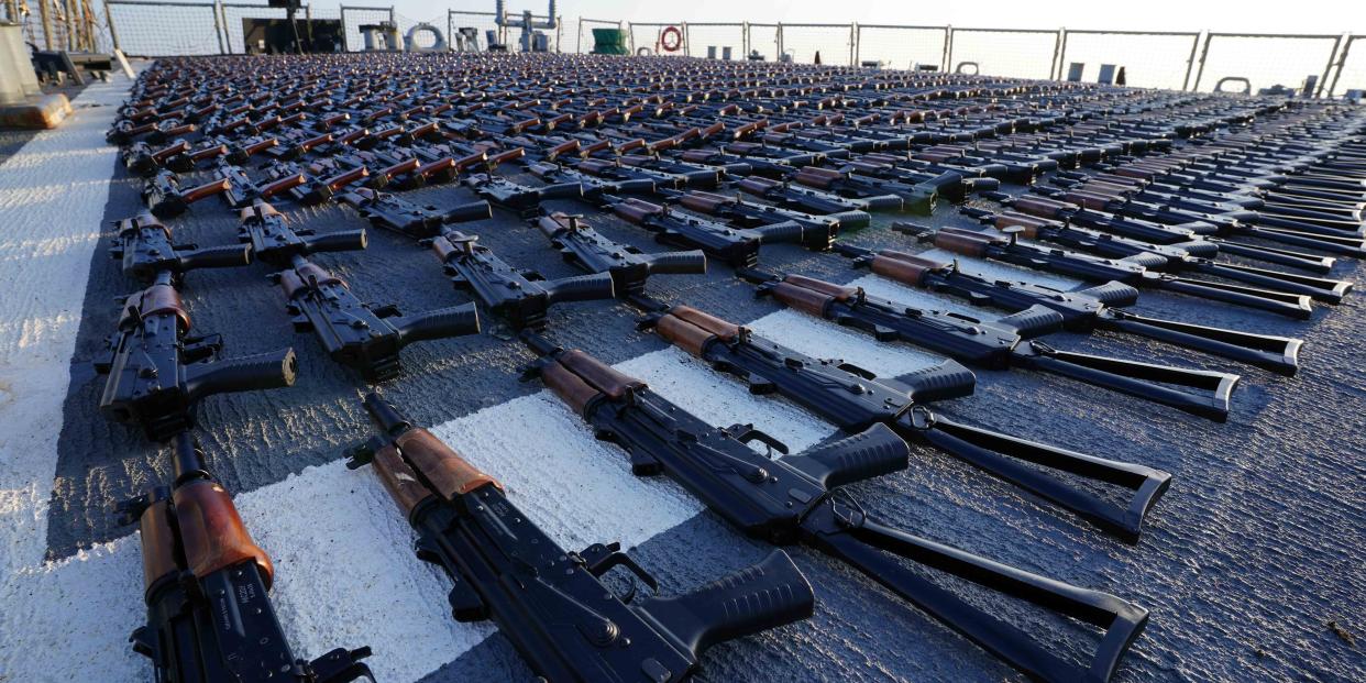 dozens of rifles laid out on deck of boat