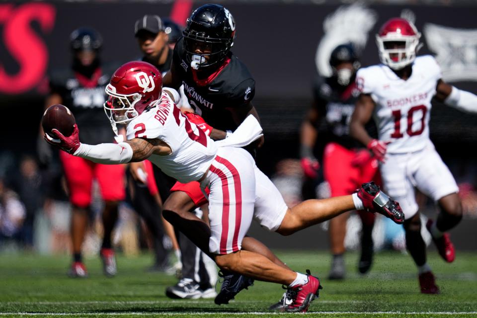 Oklahoma Sooners defensive back Billy Bowman Jr. (2) intercepts a bobbled pass in the fourth quarter of the NCAA Big 12 football game between the <a class="link " href="https://sports.yahoo.com/ncaaf/teams/cincinnati/" data-i13n="sec:content-canvas;subsec:anchor_text;elm:context_link" data-ylk="slk:Cincinnati Bearcats;sec:content-canvas;subsec:anchor_text;elm:context_link;itc:0">Cincinnati Bearcats</a> and the Oklahoma Sooners at Nippert Stadium in Cincinnati on Saturday, Sept. 23, 2023. The Bearcats lost their first Big 12 football game, 20-6, to the Sooners before a sellout crowd.