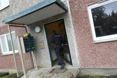 A German police officer enters a building, that also serves as an accommodation facility for refugees, in the village of Suhl, Germany, October 25, 2016. REUTERS/Kai Pfaffenbach