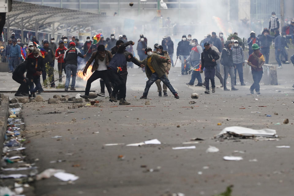 Backers of former President Evo Morales clash with police in La Paz, Bolivia, Wednesday, Nov. 13, 2019. Bolivia's new interim president Jeanine Anez faces the challenge of stabilizing the nation and organizing national elections within three months at a time of political disputes that pushed Morales to fly off to self-exile in Mexico after 14 years in power. (AP Photo/Natacha Pisarenko)