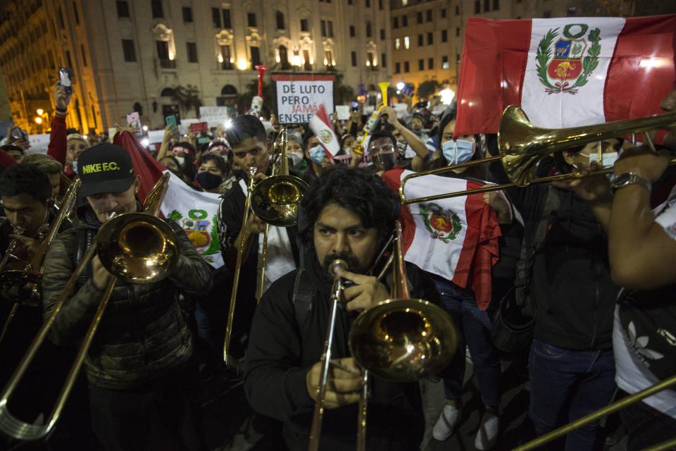 Musicians perform Peru's national anthem in San Martin square after Peru's new interim President Francisco Sagasti was designated by Congress to lead the nation, in Lima, Peru, Monday, Nov. 16, 2020. Lawmakers chose Sagasti to become the nation's third president in the span of a week after they ousted Martin Vizcarra and the following protests forced his successor Manuel Merino to resign. (AP Photo/Rodrigo Abd)