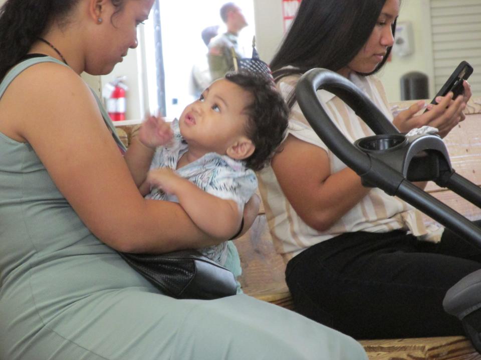 Jamimah Tamivaa and 11-month-old Peter wait for Sgt. Samuel Tamivaa on Tuesday, June 28, 2022, at Fort Bragg's Green Ramp, as Sgt. Tamivva and other paratroopers arrived home from a deployment to Poland.