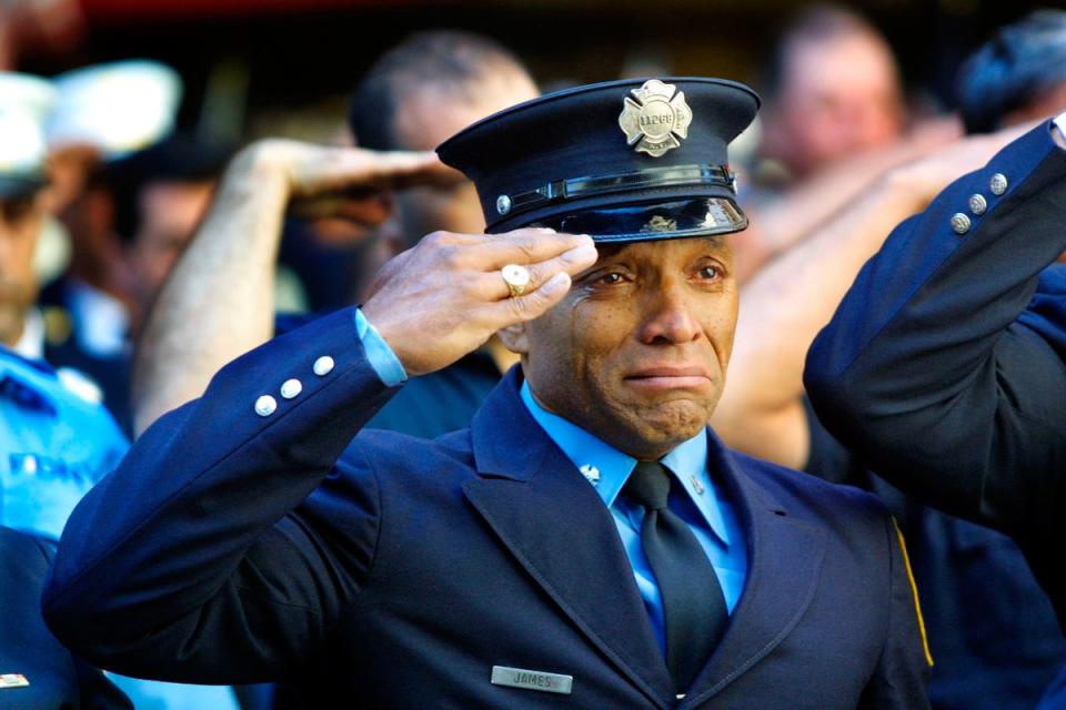 Firefighter Tony James cries while attending the funeral service for New York Fire Department Chaplain Rev Mychal Judge, in front of the St Francis of Assisi Church on 15 September, 2001. Judge died while giving the last rites to a fireman in the collapse of the World Trade Centre (Getty)