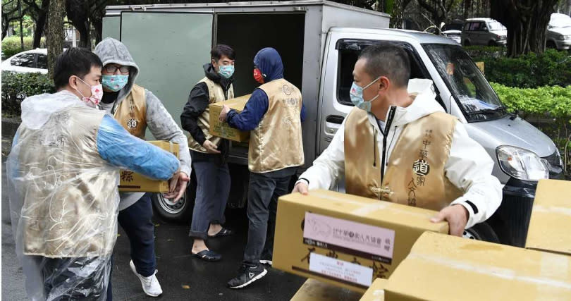 志工們在雨中同心協力搬運捐贈物資，捐粽活動已邁入第9年，累積共計1萬4500戶家庭、4萬人次受惠。（圖∕道家人文協會提供）
