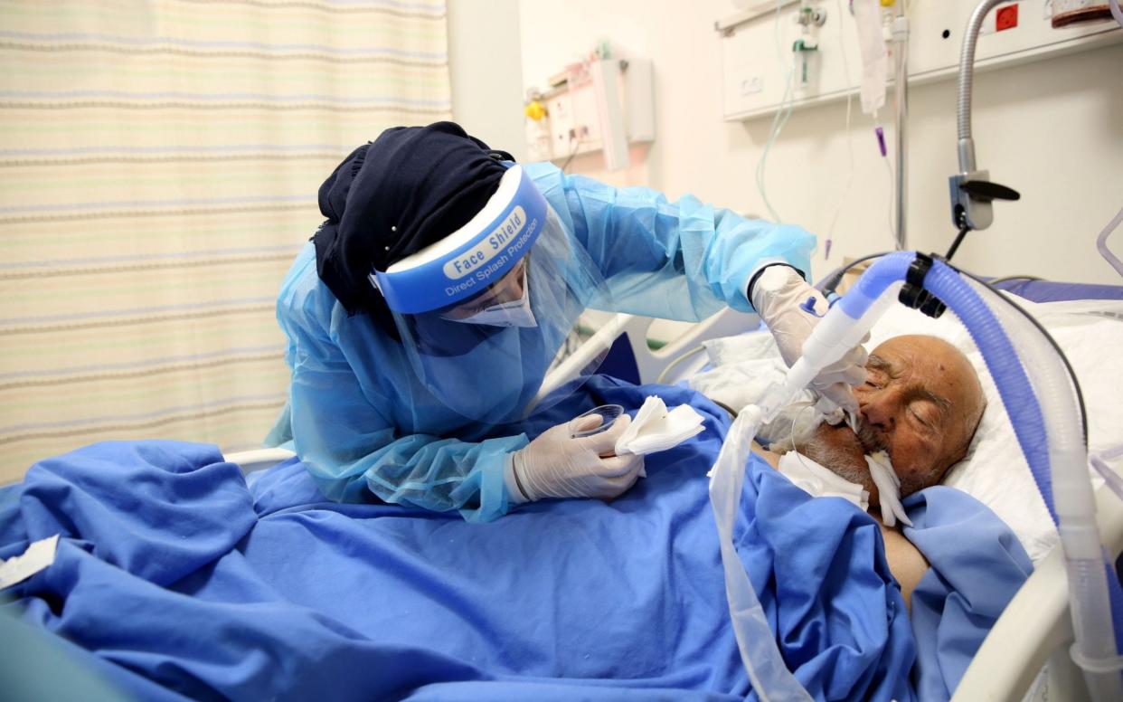 A Palestinian medical worker checks a patient at the COVID-19 section of Dura hospital in the West Bank city of Dura near Hebron - Shutterstock/Shutterstock