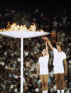 Gymnastics athlete Sandra Henderson, left, and track and field athlete Stéphane Préfontaine Lighting of the Olympic Flame during the 1976 Montreal Olympics, July 17, 1976. (AP Photo)