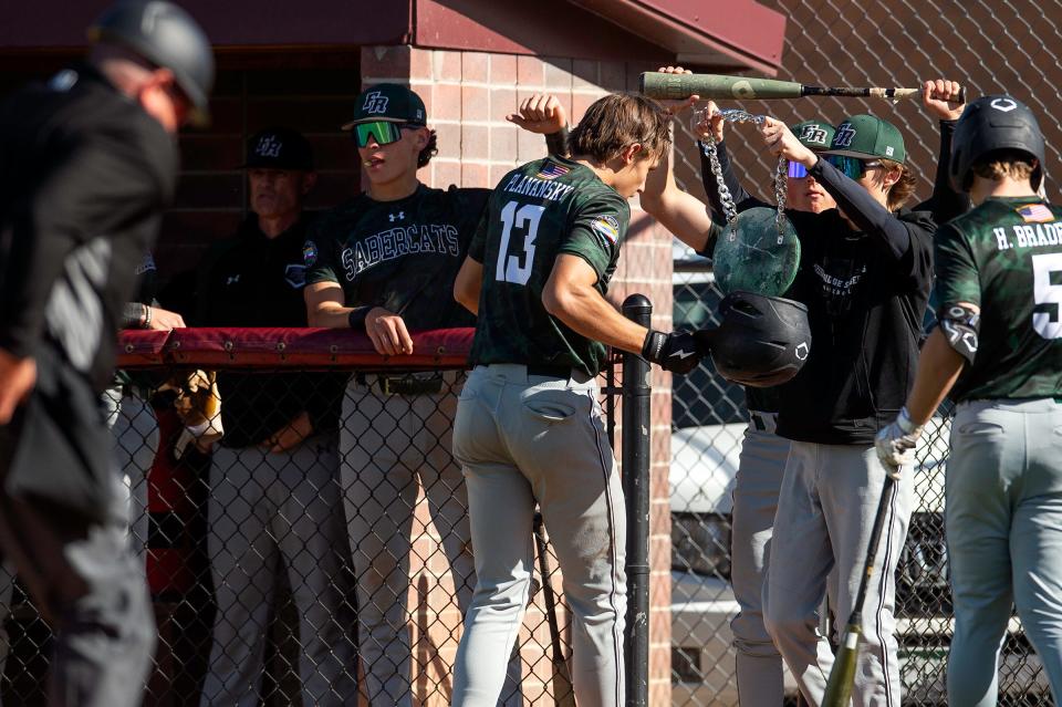 Fossil Ridge's Jensen Planansky gets a chain put around his neck after hitting a home run during a city rivalry baseball game against Rocky Mountain on Tuesday at Gabe Pando Park in Fort Collins.