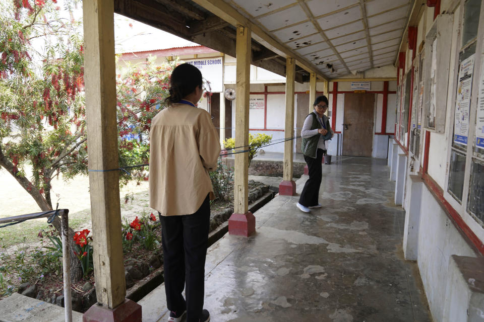 Polling officers Neichutuonuo Yhome, 27, right, and Neke W Konyak, 29, secure the perimeter around their assigned polling station on the eve of polls in Chedema village, in the northeastern Indian state of Nagaland, Thursday, April 18, 2024. (AP Photo/Yirmiyan Arthur)