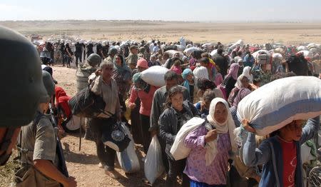 Turkish soldiers stand guard as Syrian Kurds cross the border fence into Turkey near the southeastern town of Suruc in Sanliurfa province, September 19, 2014. REUTERS/Stringer