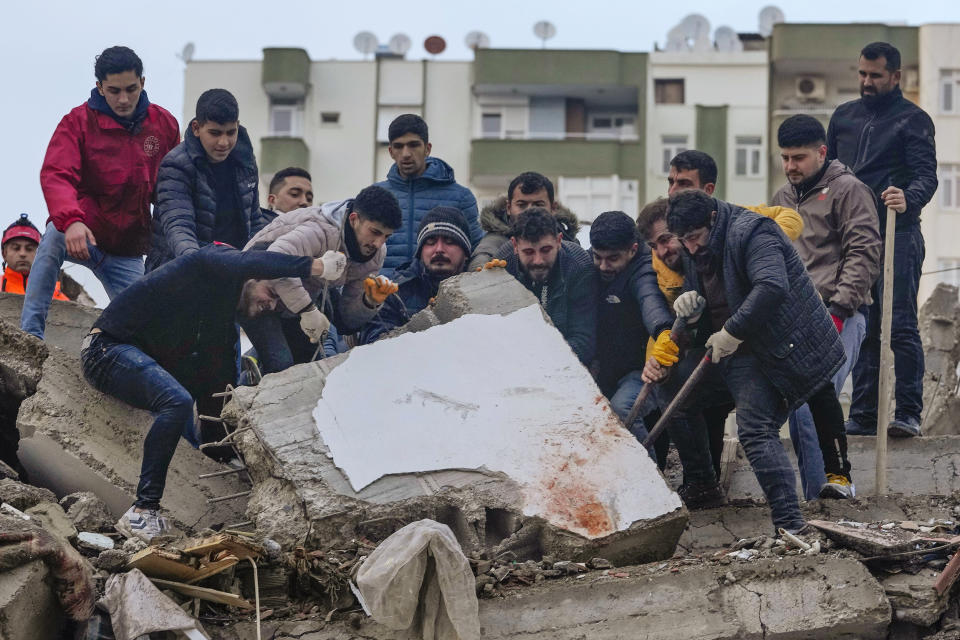 Men search for survivors in the debris in Adana, Turkey, on Feb. 6, 2023. (Khalil Hamra / AP)