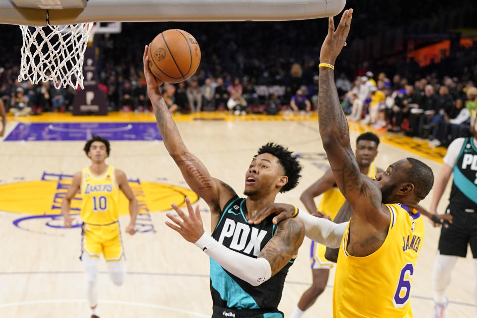 Portland Trail Blazers guard Anfernee Simons, second from left, shoots as Los Angeles Lakers forward LeBron James defends during the first half of an NBA basketball game Wednesday, Nov. 30, 2022, in Los Angeles. (AP Photo/Mark J. Terrill)