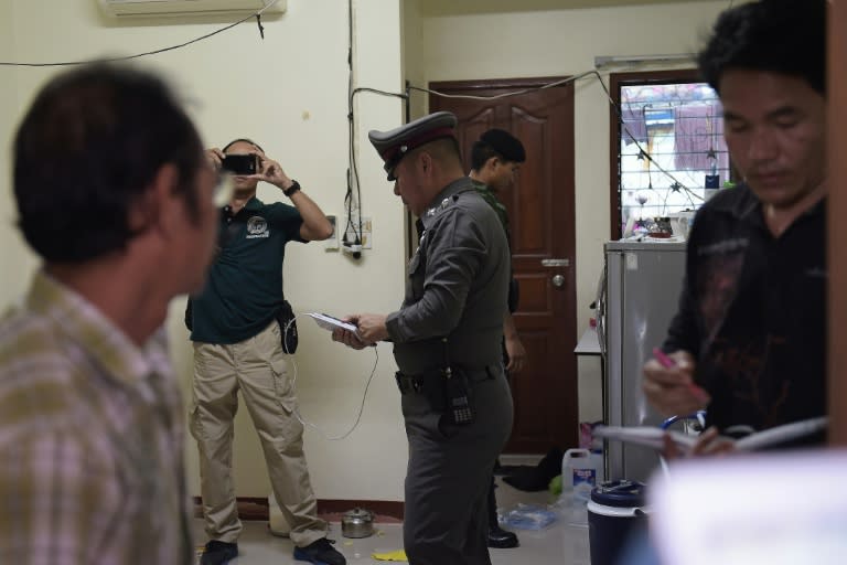 Policemen conduct a search operation at apartment blocks on the outskirts of Bangkok on August 30, 2015