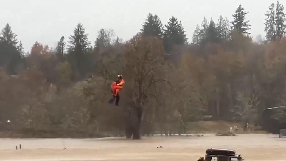 An MH-60 Jayhawk helicopter aircrew from Coast Guard Air Station Astoria rescues five people who were trapped in flooding conditions in Rosburg, Washington.