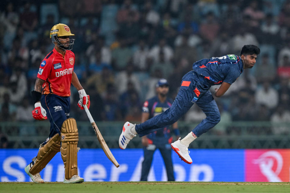 TOPSHOT - Lucknow Super Giants' Mayank Yadav bowls as Punjab Kings' captain Shikhar Dhawan (L) watches during the Indian Premier League (IPL) Twenty20 cricket match between Lucknow Super Giants and Punjab Kings at the Ekana Cricket Stadium in Lucknow on March 30, 2024. (Photo by Arun SANKAR / AFP) / -- IMAGE RESTRICTED TO EDITORIAL USE - STRICTLY NO COMMERCIAL USE -- (Photo by ARUN SANKAR/AFP via Getty Images)