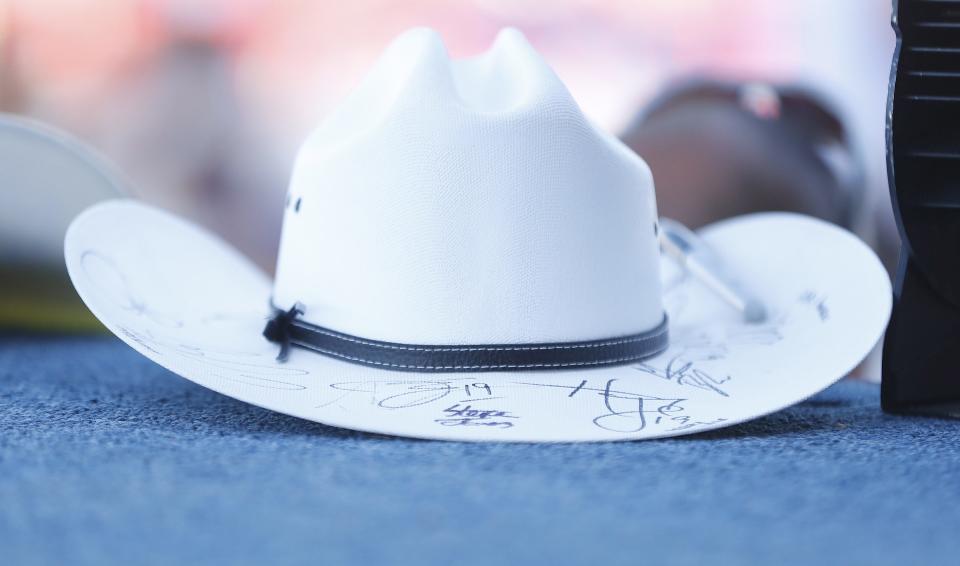 Fans place their cowboy hats on the stage during Country Thunder in Florence, Arizona, on April 13, 2019.