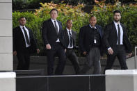 Tesla CEO Elon Musk, second from left, arrives at U.S. District Court Wednesday, Dec. 4, 2019, in Los Angeles. Musk is going on trial for his troublesome tweets in a case pitting the billionaire against a British diver he allegedly dubbed a pedophile. (AP Photo/Mark J. Terrill)