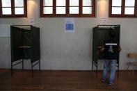 A worker arranges a voting booth inside a polling station during a voting simulation ahead of the upcoming referendum on a new Chilean constitution in Santiago