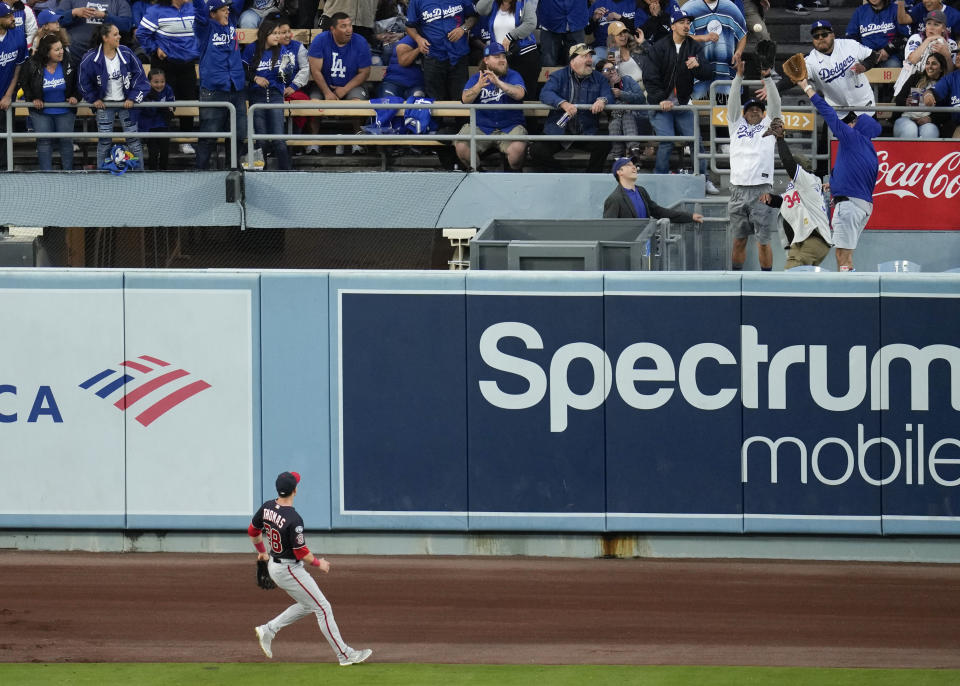 Washington Nationals center fielder Lane Thomas (28) watches as fans catch a home run ball hit by Los Angeles Dodgers' Jason Heyward during the second inning of a baseball game in Los Angeles, Tuesday, May 30, 2023. (AP Photo/Ashley Landis)