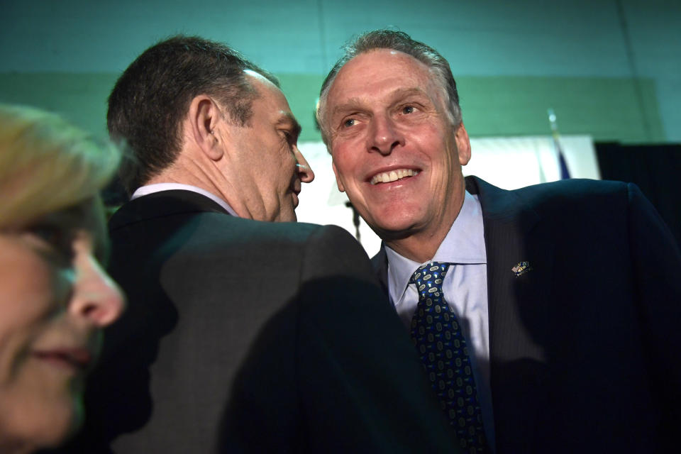 Virginia Gov. Ralph Northam, center, talks with former Virginia Gov. Terry McAuliffe, right, before the start of a news conference in the Crystal City neighborhood in Arlington, Va., Tuesday, Nov. 13, 2018. Amazon, which has grown too big for its Seattle hometown, said it will split its much-anticipated second headquarters between New York and northern Virginia. (AP Photo/Susan Walsh)